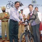 Urban Affair Minister Ampareen Lyngdoh hand over a bycycle to a teacher from one of the school in the city at a function crpf