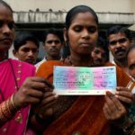 Tribals displaying cheque for PM