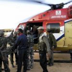 Security personnel shift injureds to a helicopter