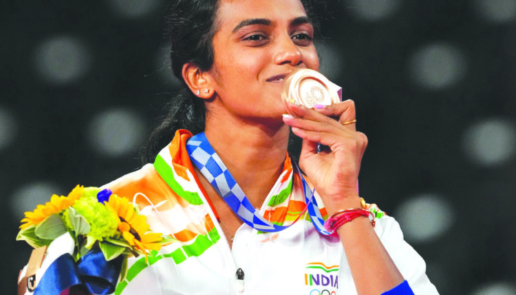 Pusarla V. Sindhu poses for photographs while standing on the podium ...