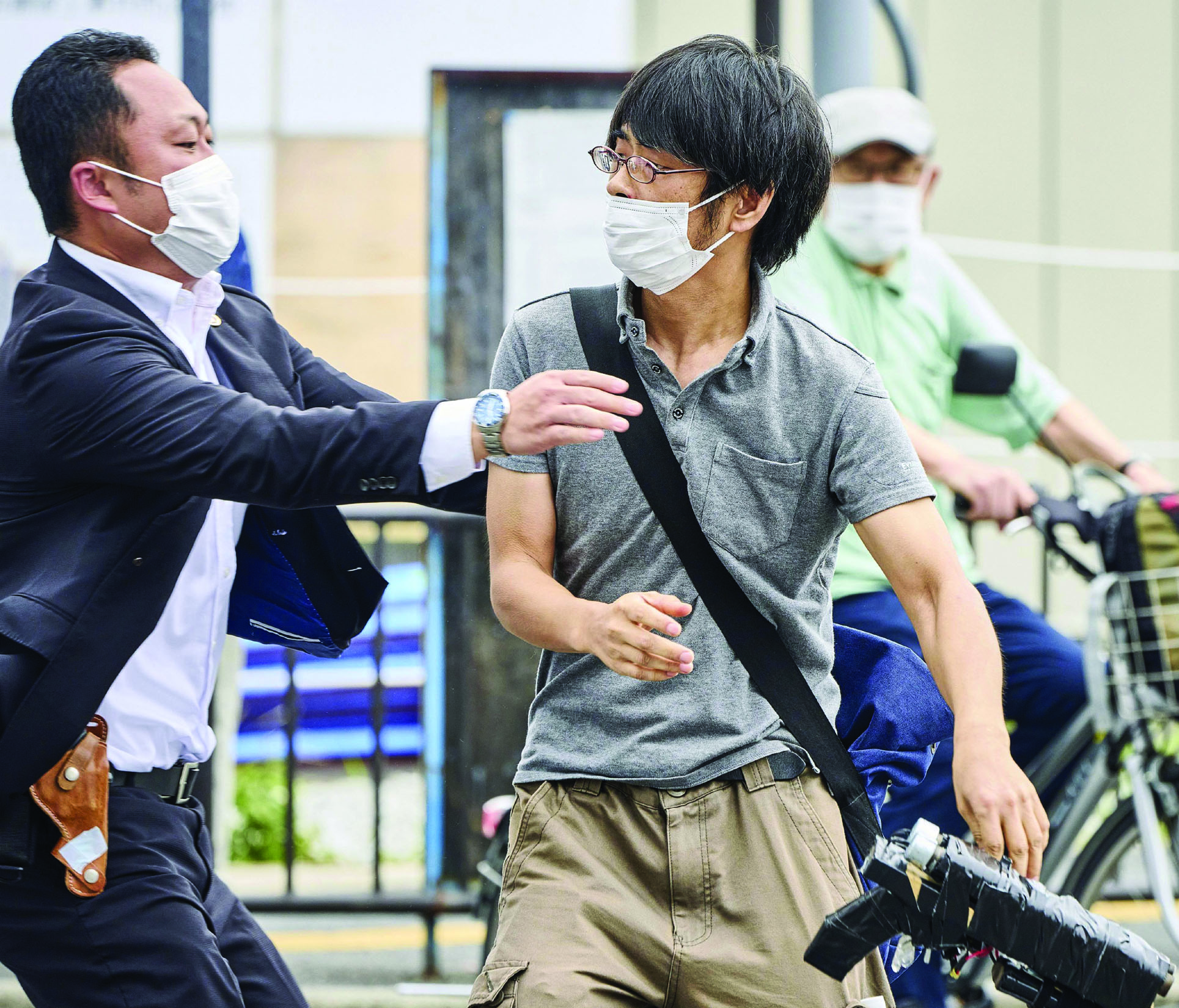 Tetsuya Yamagami (right) is detained near the site after shooting former Ja...