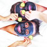 Happy couple having facial in spa salon