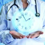 Doctor shows the clock on the background of internal organs .